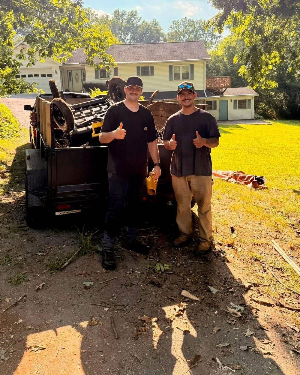 Nick and William, the owners of Clean Slate Junk Removal, standing beside a loaded dump trailer after a property cleanup near Colora in Cecil County, Maryland